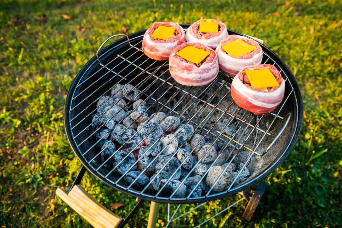 Bacon wrapped beer can burgers grilling indirect on a charcoal gr.