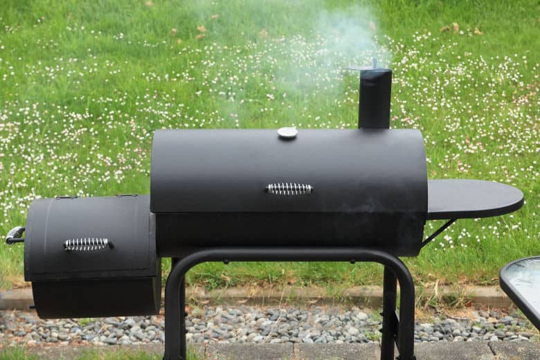 Close up of black offset smoker against grass background
