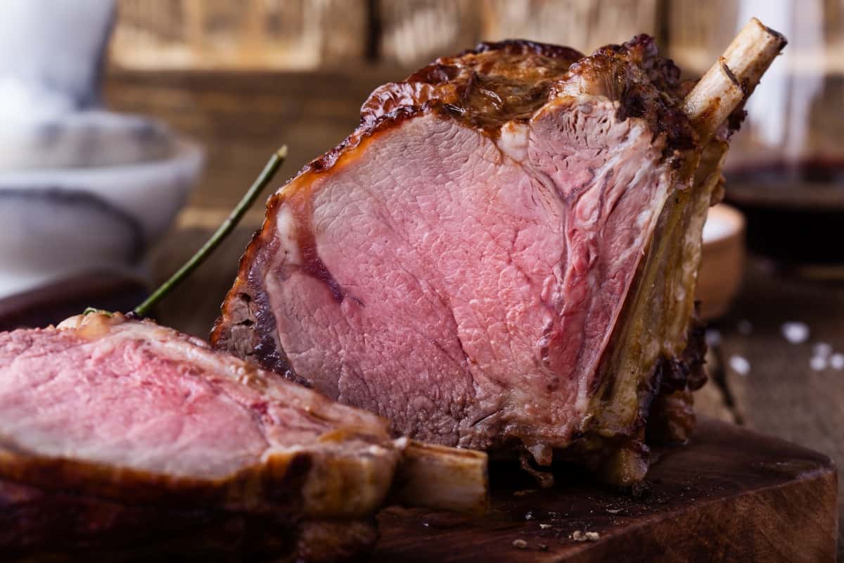 A sliced bone in prime rib roast showing how perfectly medium rare it is ins.