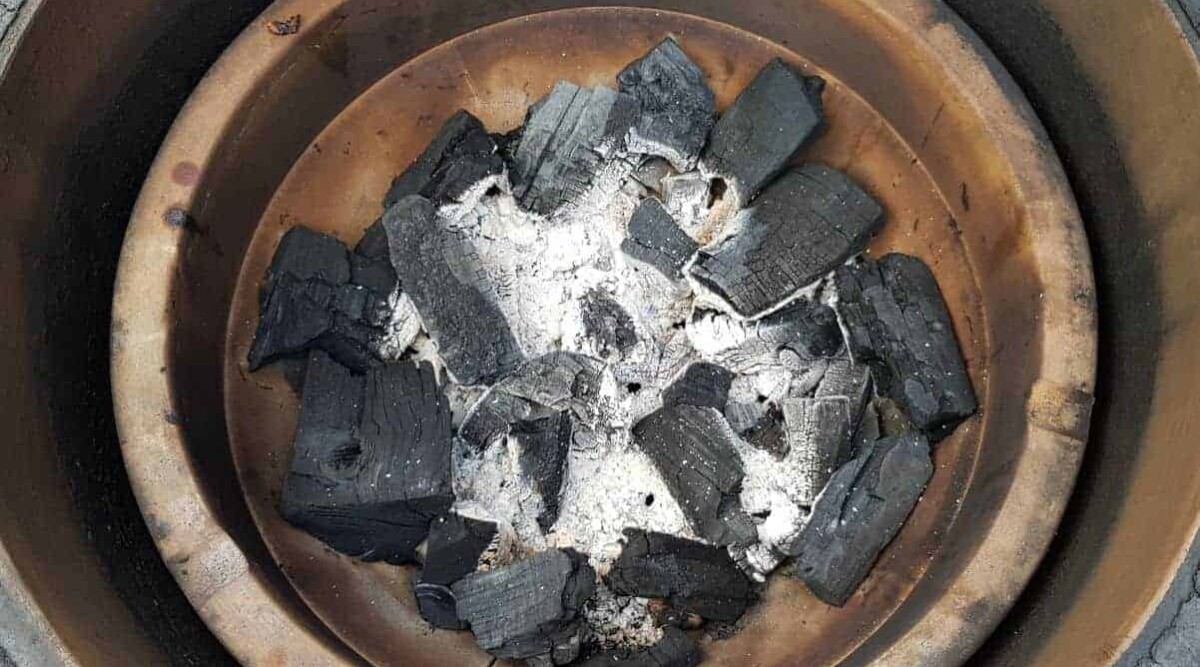 A shot of half burnt charcoal in a kamado Joe fire bowl.