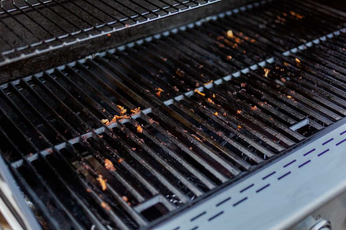 Close up of dirty gas grill cast iron gra.