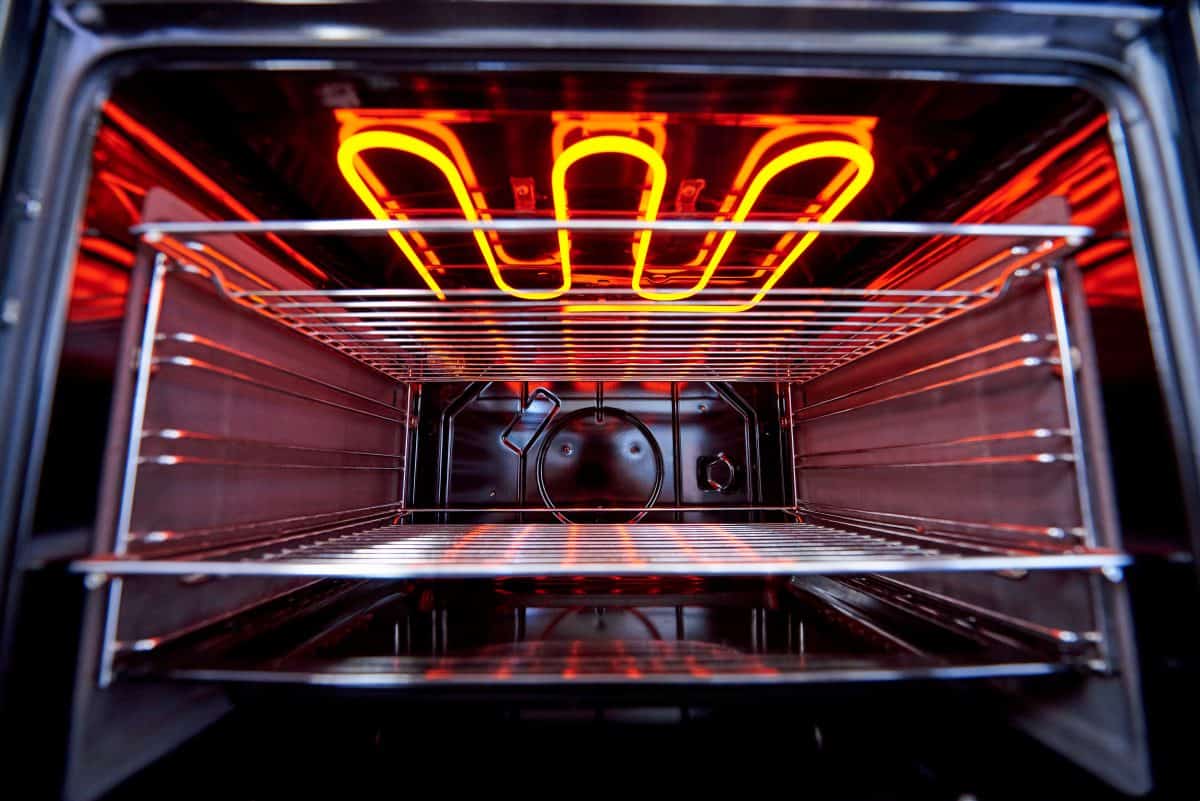 A glowing red-hot, kitchen oven broiler seen from be.