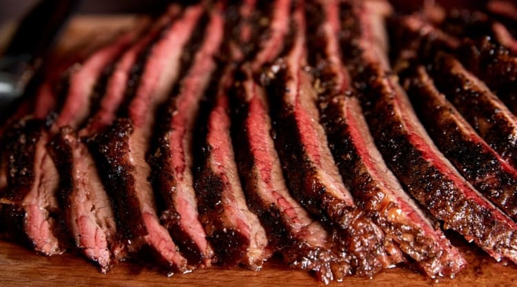 Moist looking sliced smoked brisket with a smoke ring.