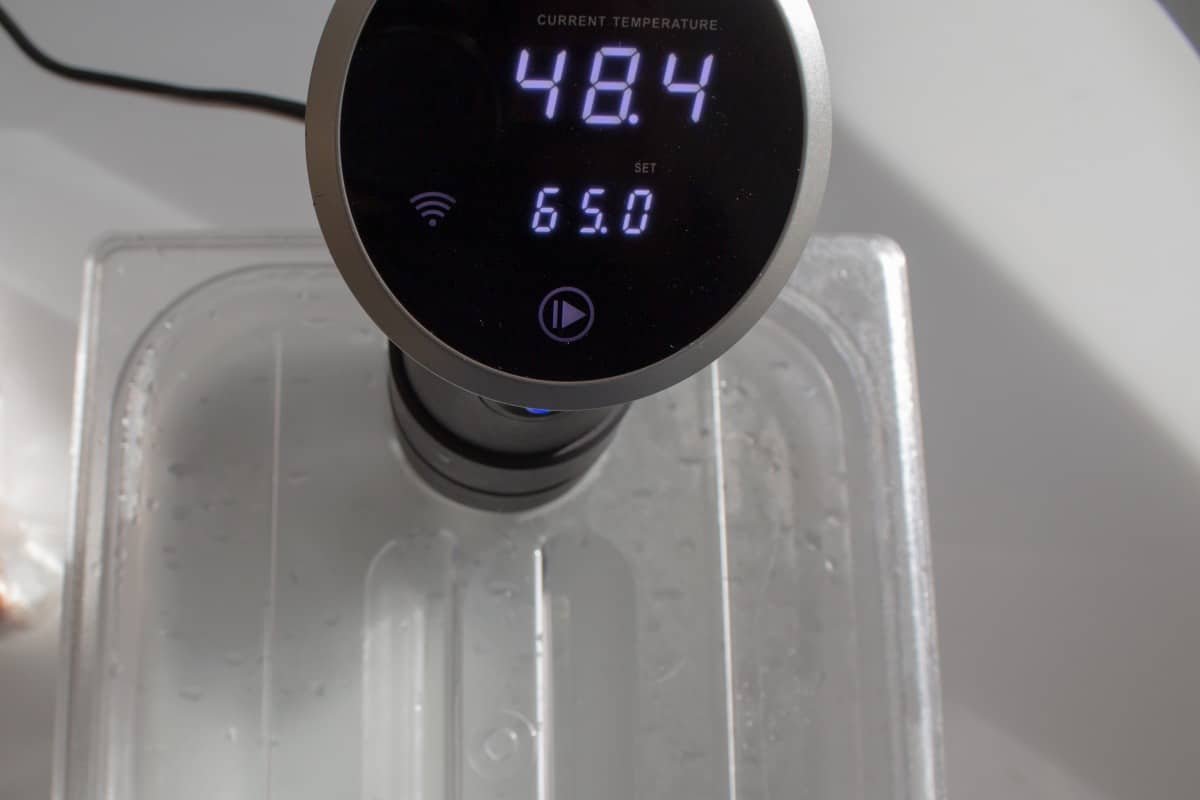 sous vide wand reading 48.4, sitting in a bath of wa.