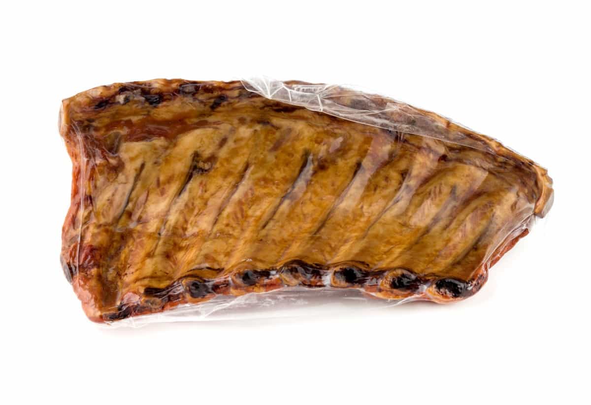 vacuum packed smoked ribs isolated on wh.