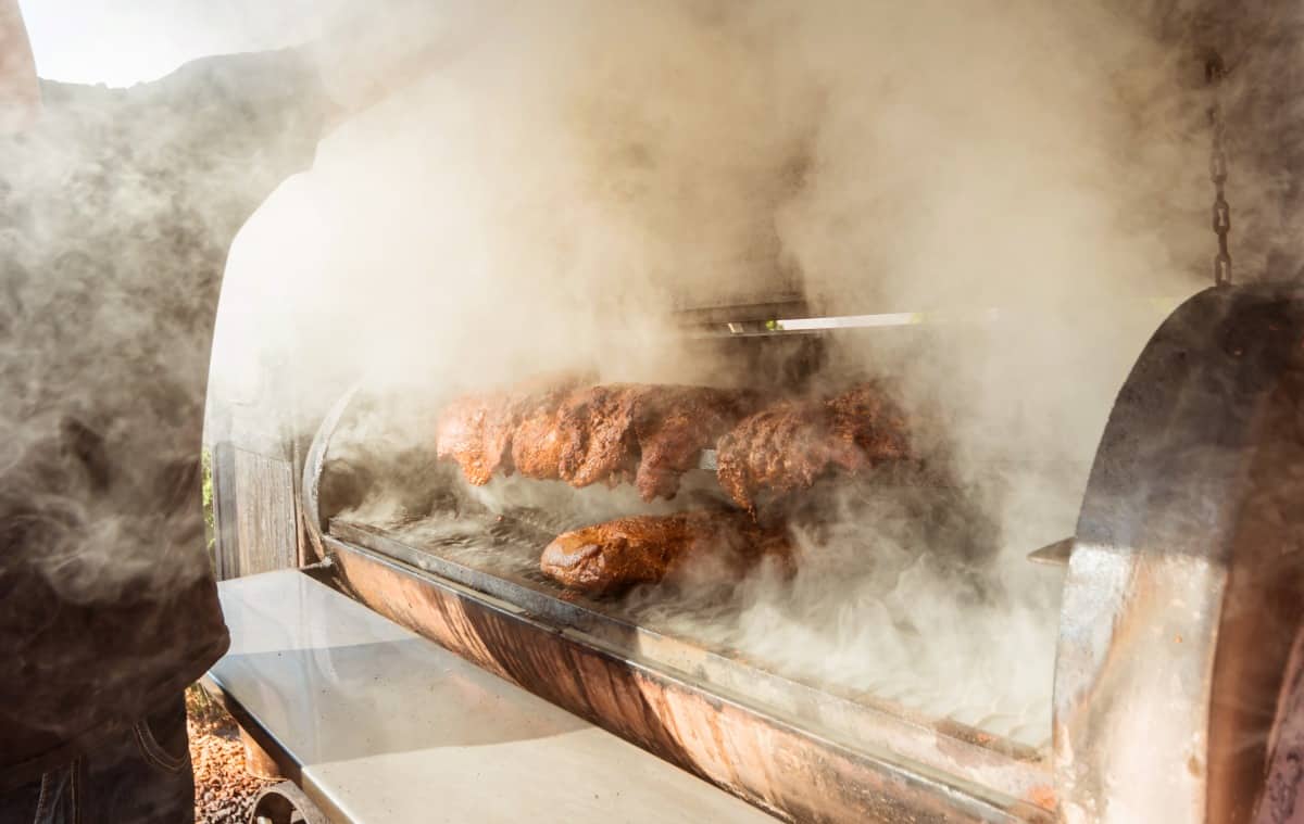 Smoke pouring a recently opened, large offset style BBQ smo.