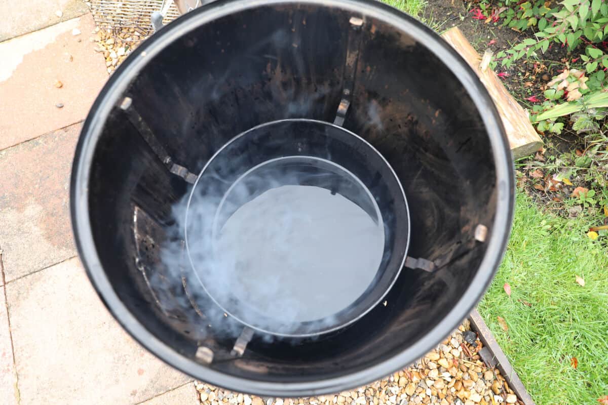 An overhead shot of the water pan inside a Weber Smoky Mountain smoker.