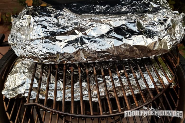 Racks of ribs, wrapped in foil and back on the grill Texas crutch style