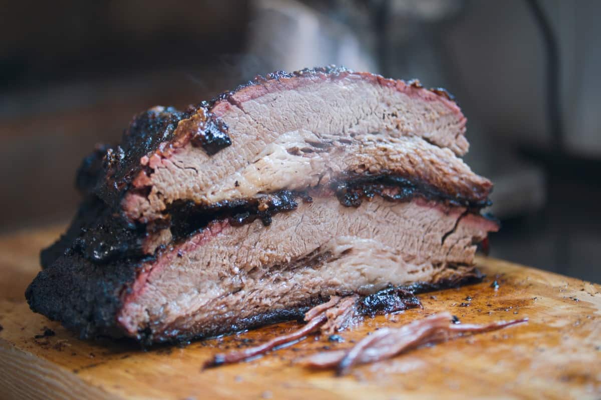 A beef brisket sliced in half with one on top of the ot.