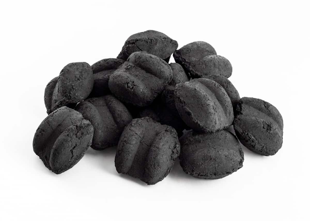 Small pile of charcoal briquettes isolated on wh.