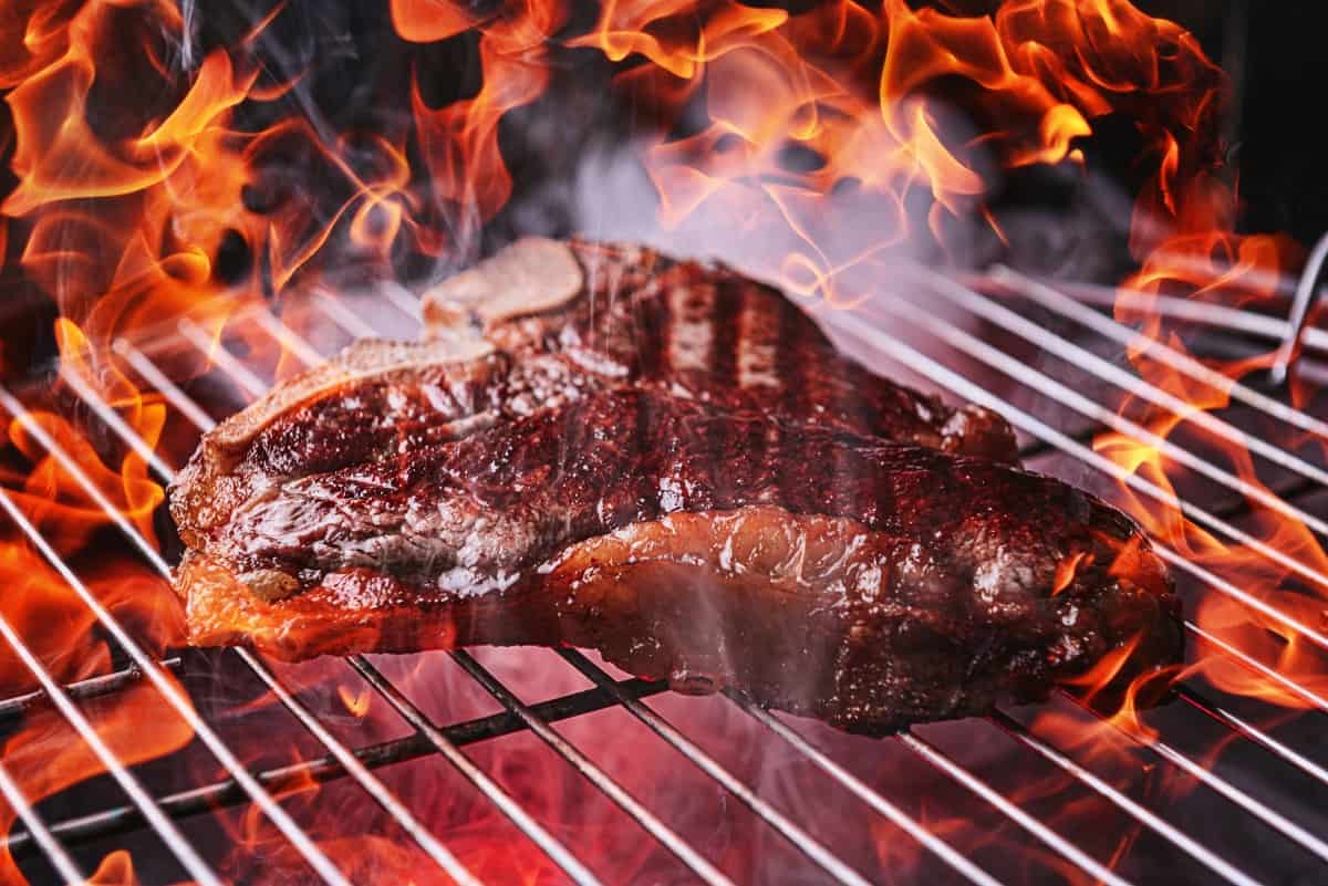 Steak cooking over a charcoal grill f.