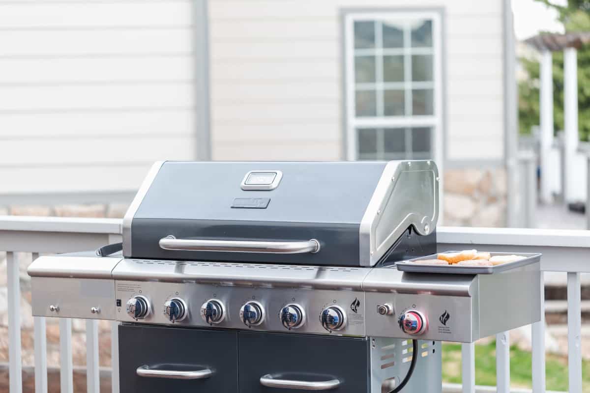 A 6 burner gas grill with lid clo.