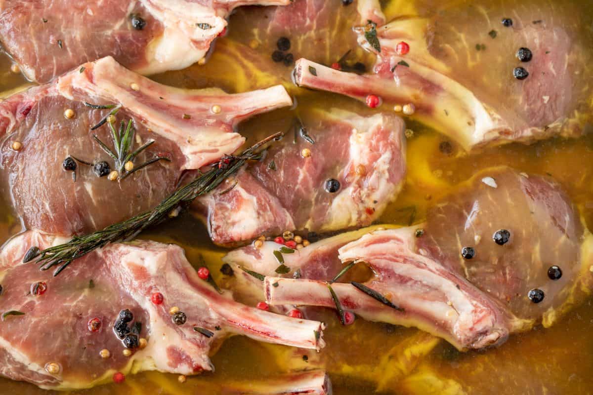 Lamb cutlets marinating in a white dish