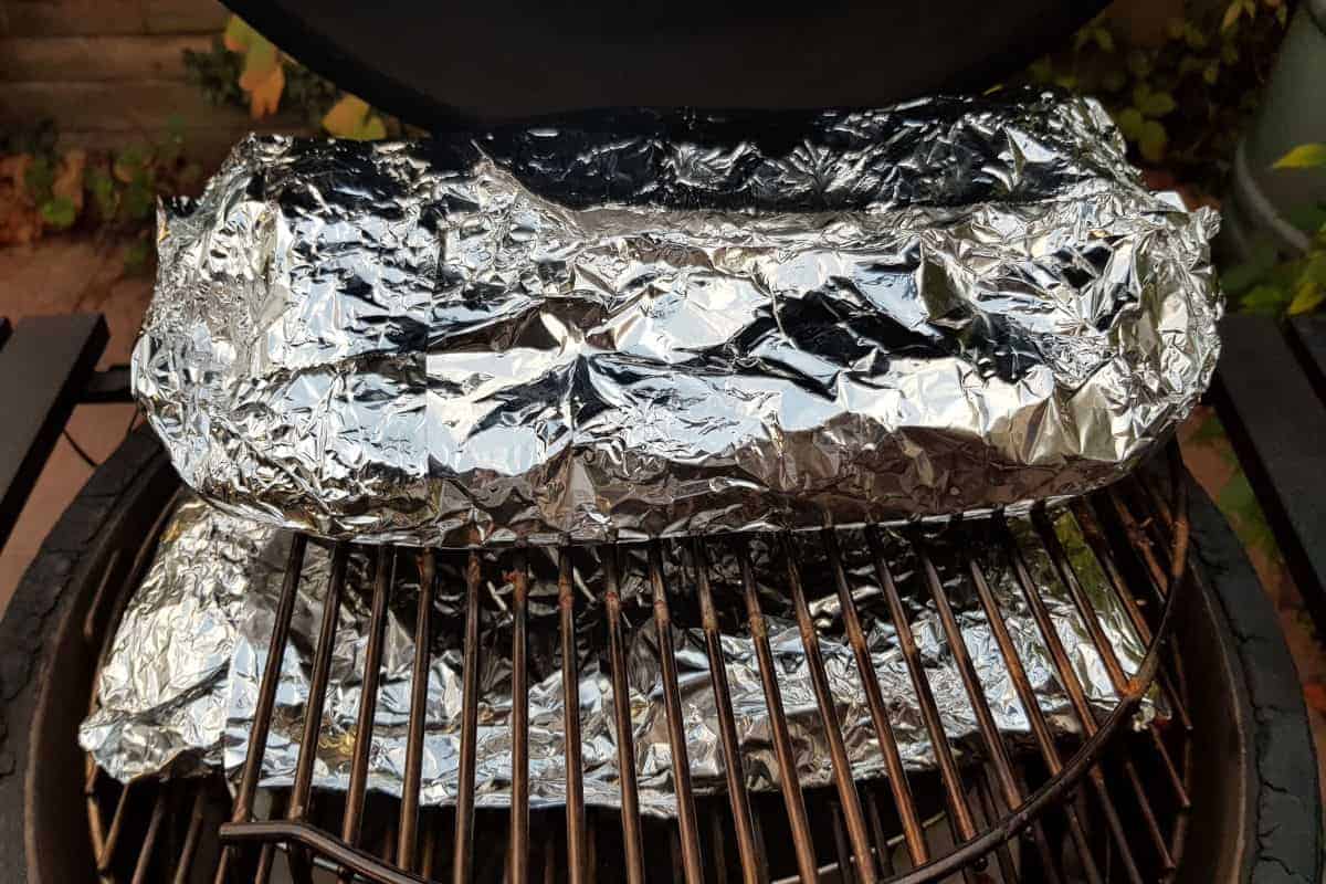 Racks of ribs, wrapped in foil and back on the grill Texas crutch style