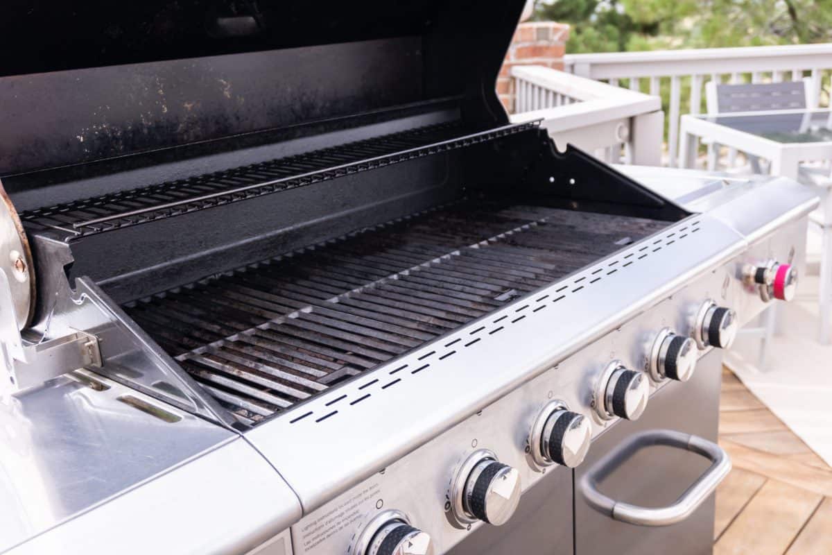 A used 6-burner gas grill with lid open