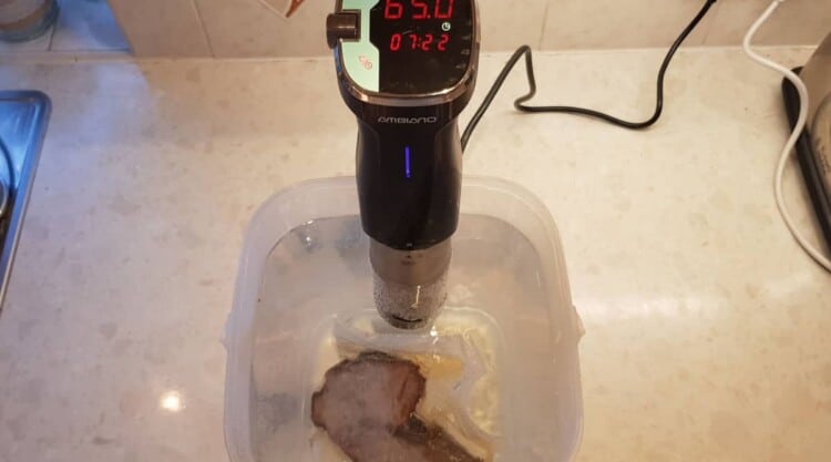Brisket being reheated with the use of a sous vide wand.