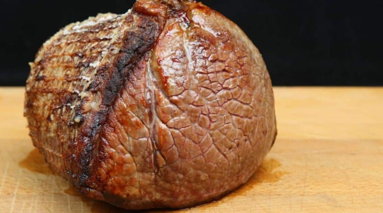 A joint of roast beef resting on a chopping board