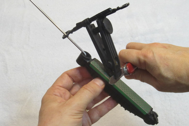 A Swiss army knife being sharpened on a knife sharpening sys.