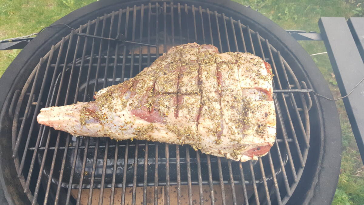 A dry rubbed lamb leg on a kamado joe, ready to be smoked.