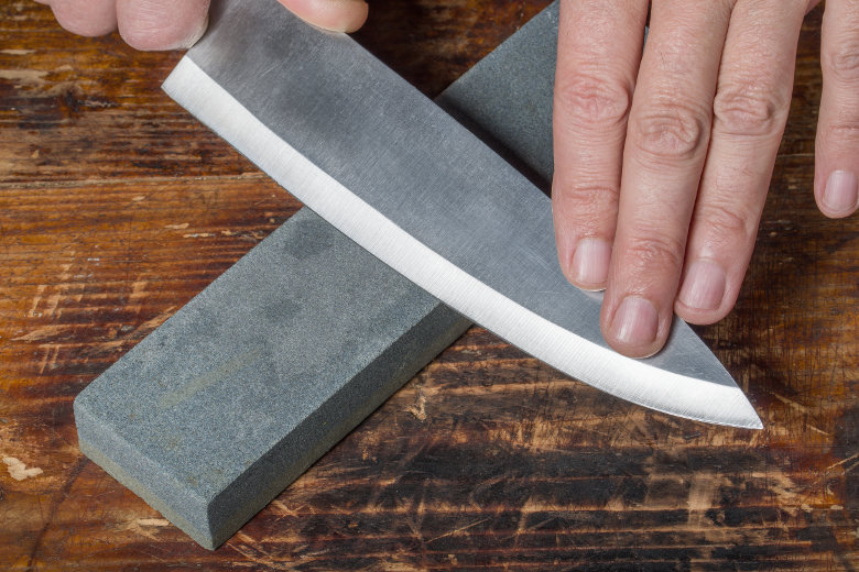 Image of a knife being sharpened on a whetstone