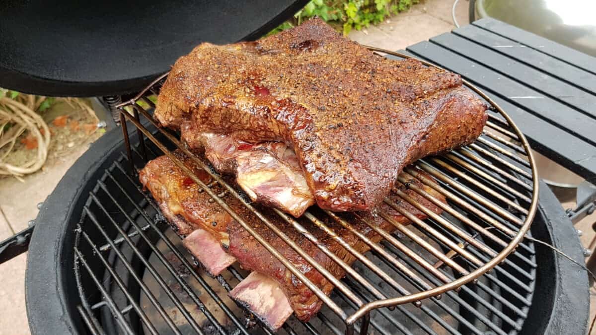 Two racks of beef ribs being smoked on a Kamado Joe grill.