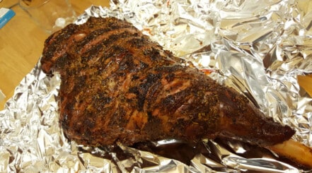 Lamb leg sitting on foil, about to be wrapped and rested until carryover cooking ends