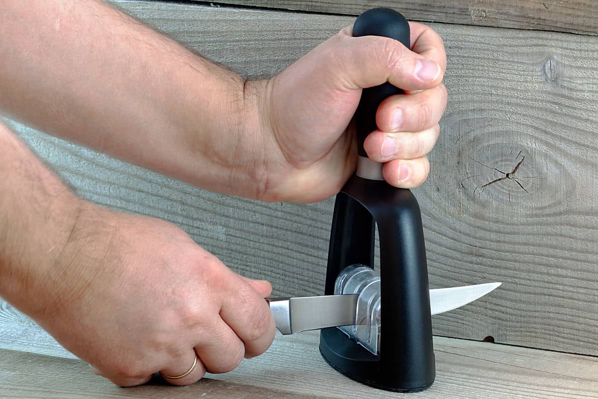 a handheld pull through knife sharpener being used