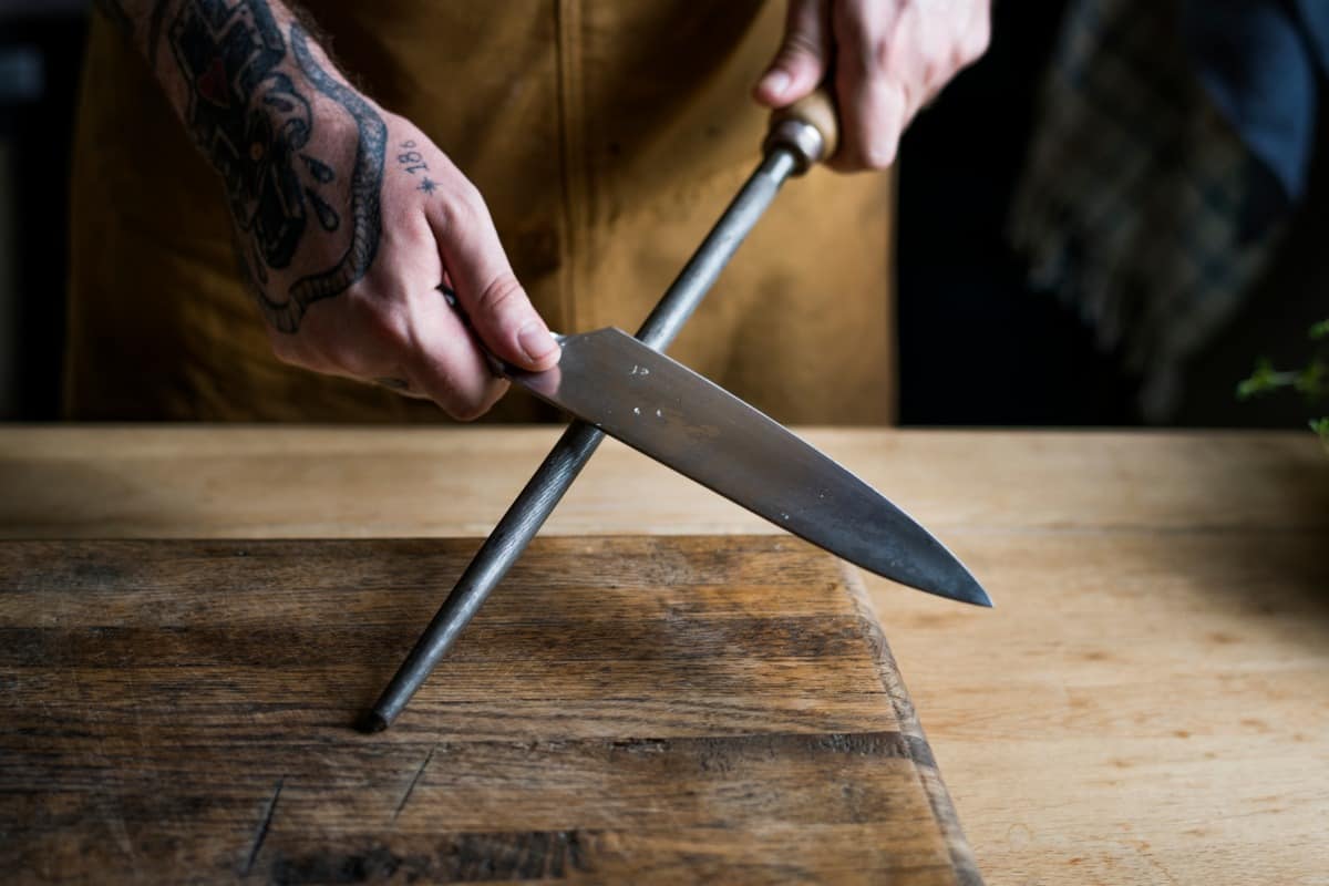 A honing steel anchored to a cutting board while in use