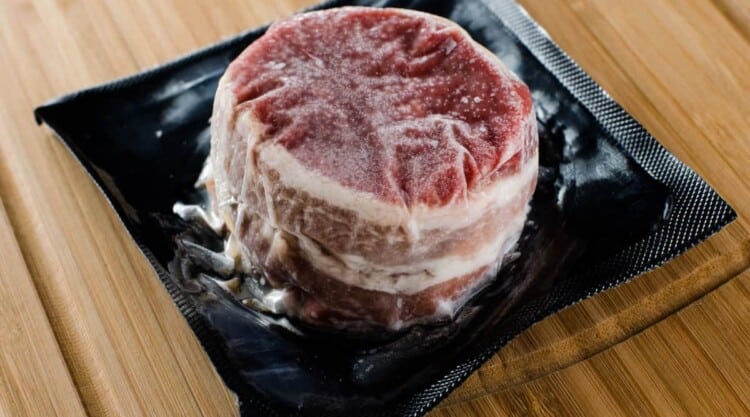 A close up shot a vacuum packed frozen steak