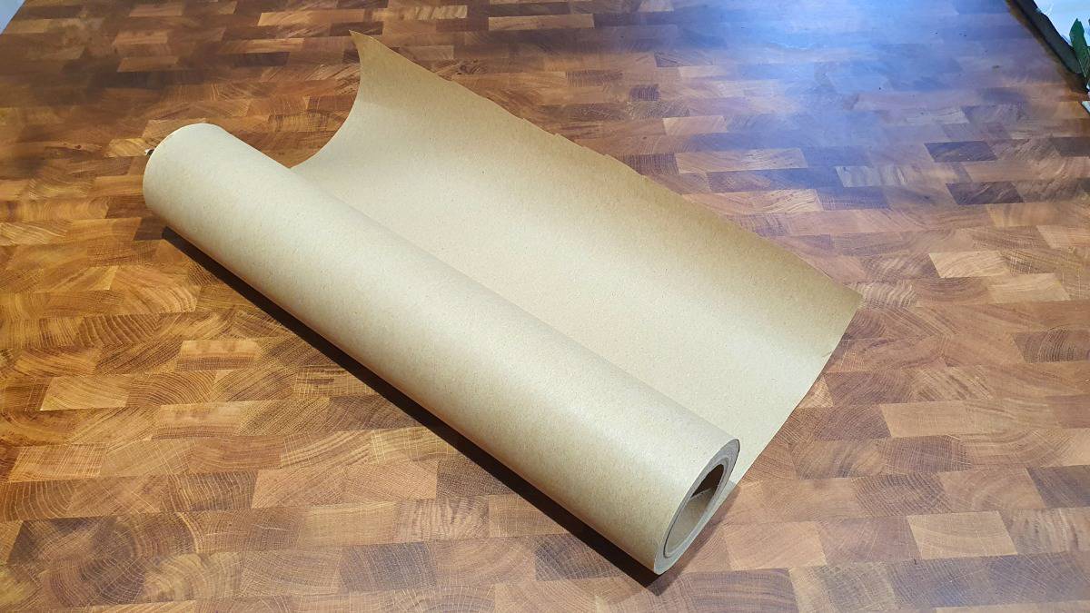 A roll of pink butcher paper on a wooden ta.