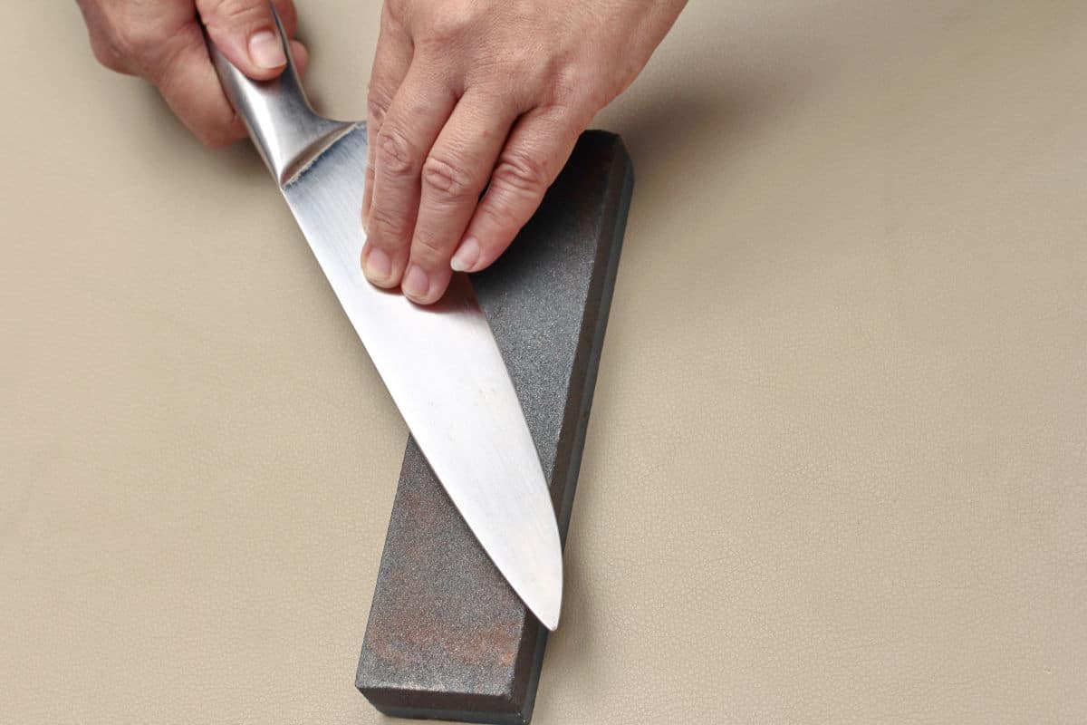 Knife being sharpened on a whetst.