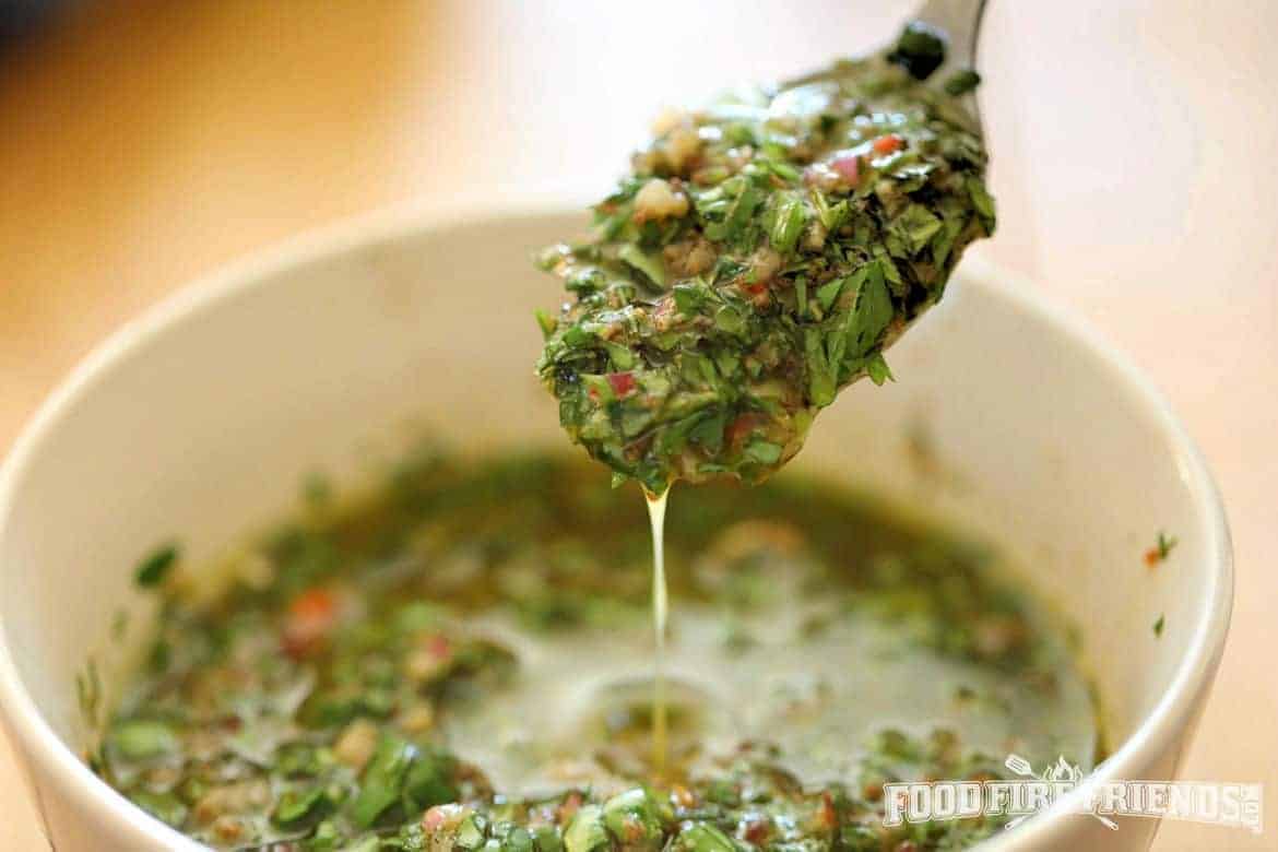 Chimichurri dripping from a spoon into a b.