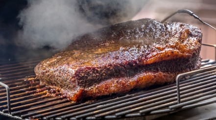 A whole packer brisket on a charcoal smoker.