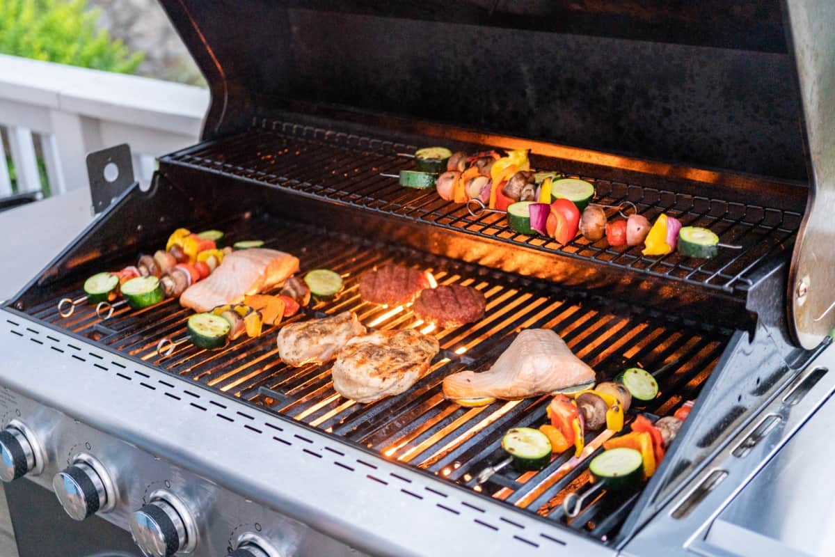 A gas grill loaded with Atlantic salmon and vegetable keb.