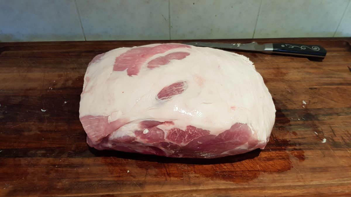 Pork butt on a cutting board with fat cap side up