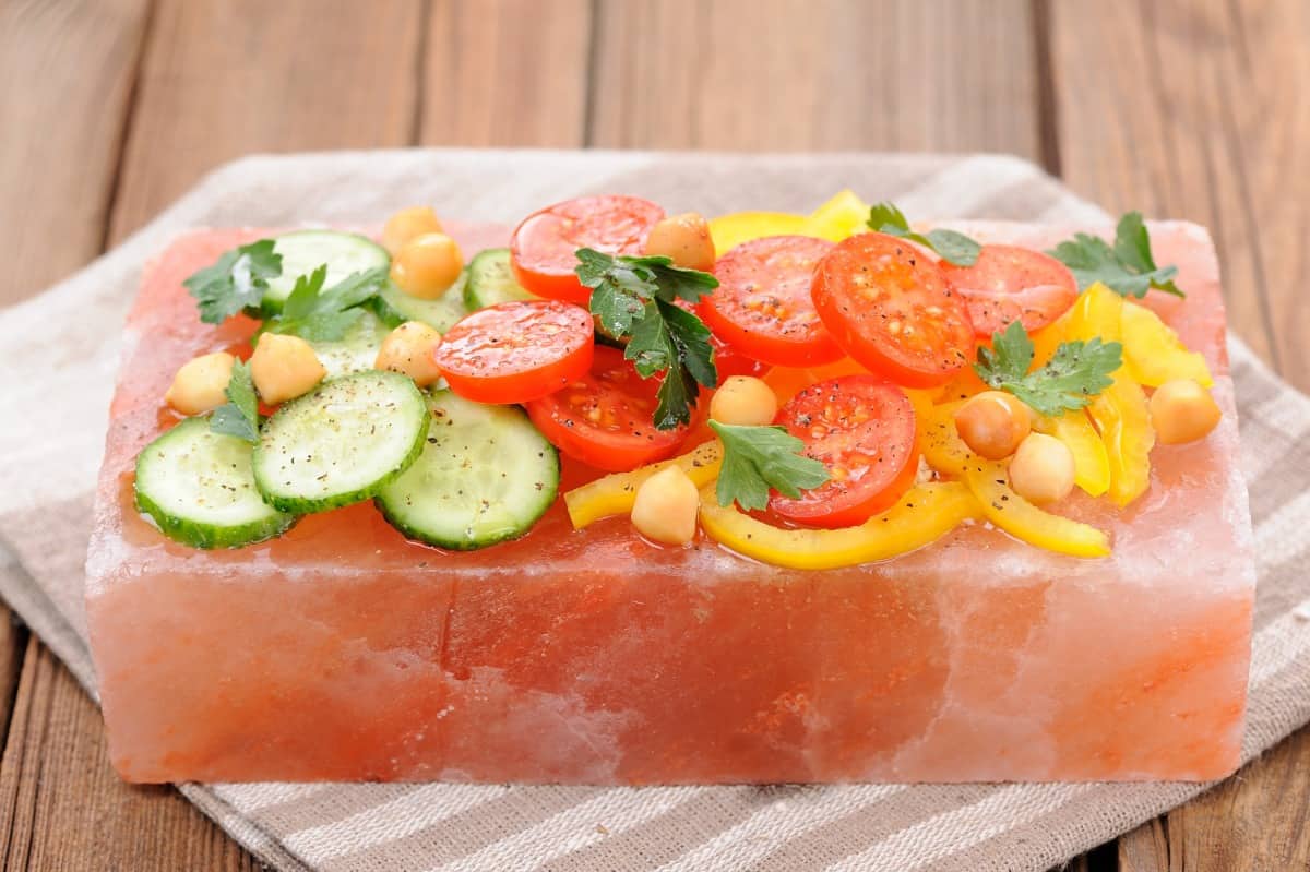 A vegetable salad chilling on a pink salt bl.