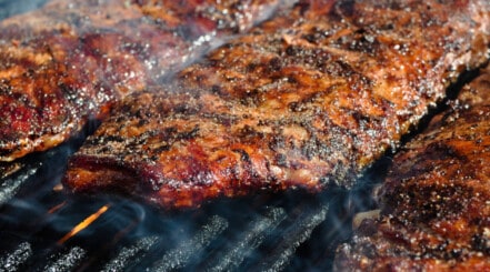 3 racks of ribs sitting on a grill.