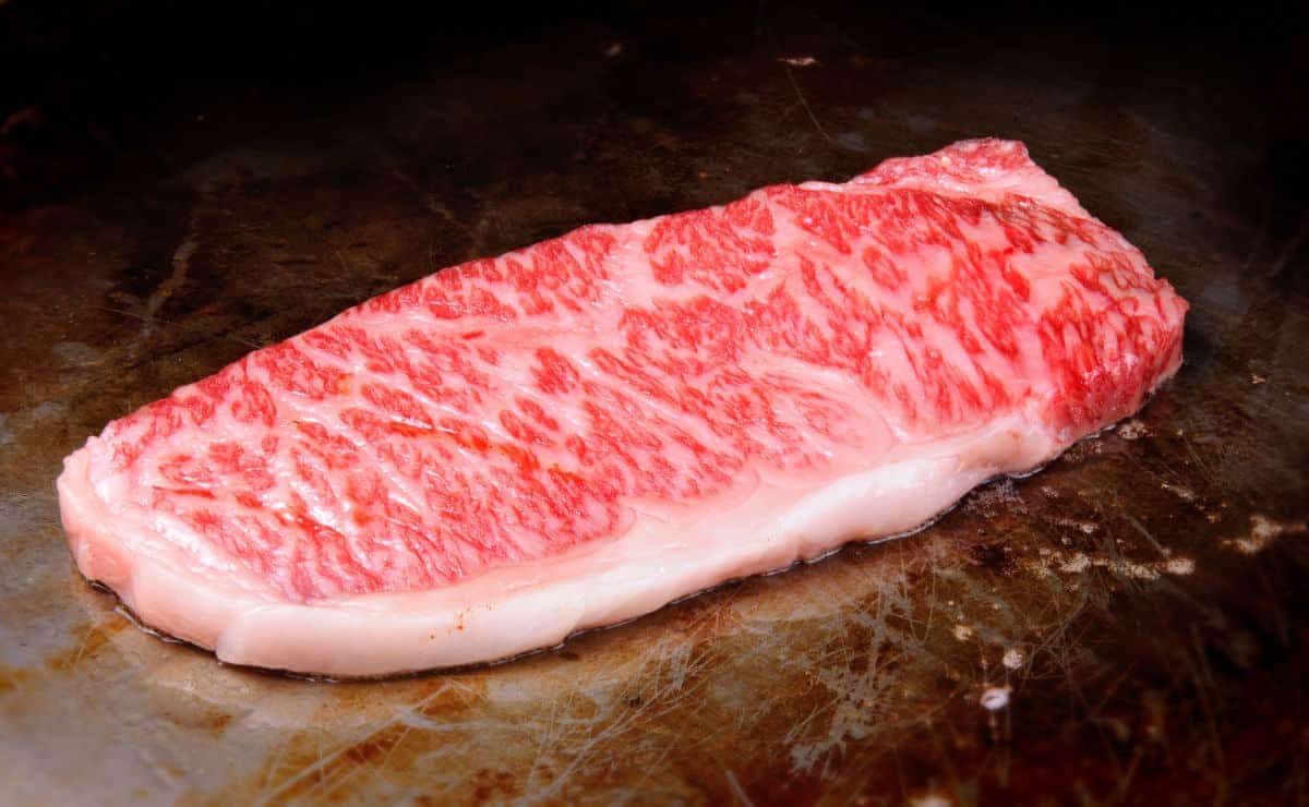 Some Wagyu beef cooking on a hot plate / grid.