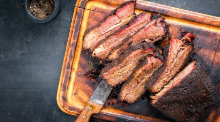A smoked and sliced wagyu brisket on a cutting board.