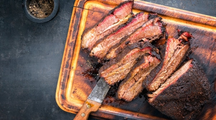 A smoked and sliced wagyu brisket on a cutting board.