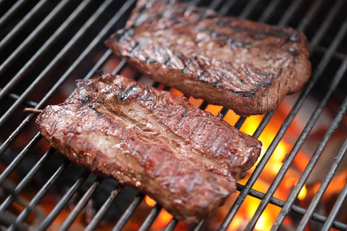 2 hanger steaks being seared on a screaming hot grill