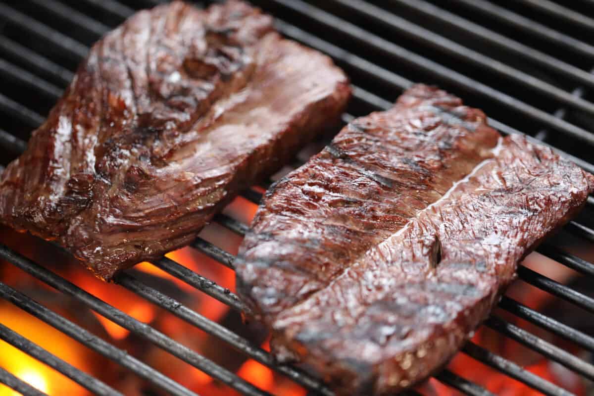  Hanger steak on a grill with red-hot coals seen be.