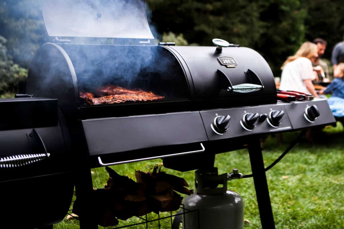 Oklahoma Joe Longhorn combo grill and smoker being used, lid open, smoke coming from gr.