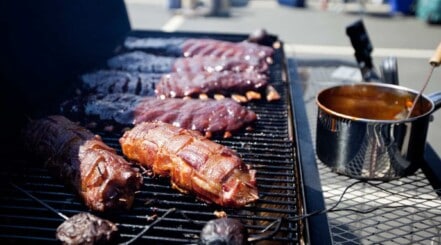 Ribs cooking on a charcoal gas combo grill.