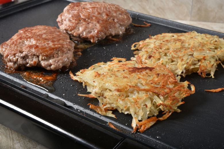 Sausage patties and hash browns on an electric griddle