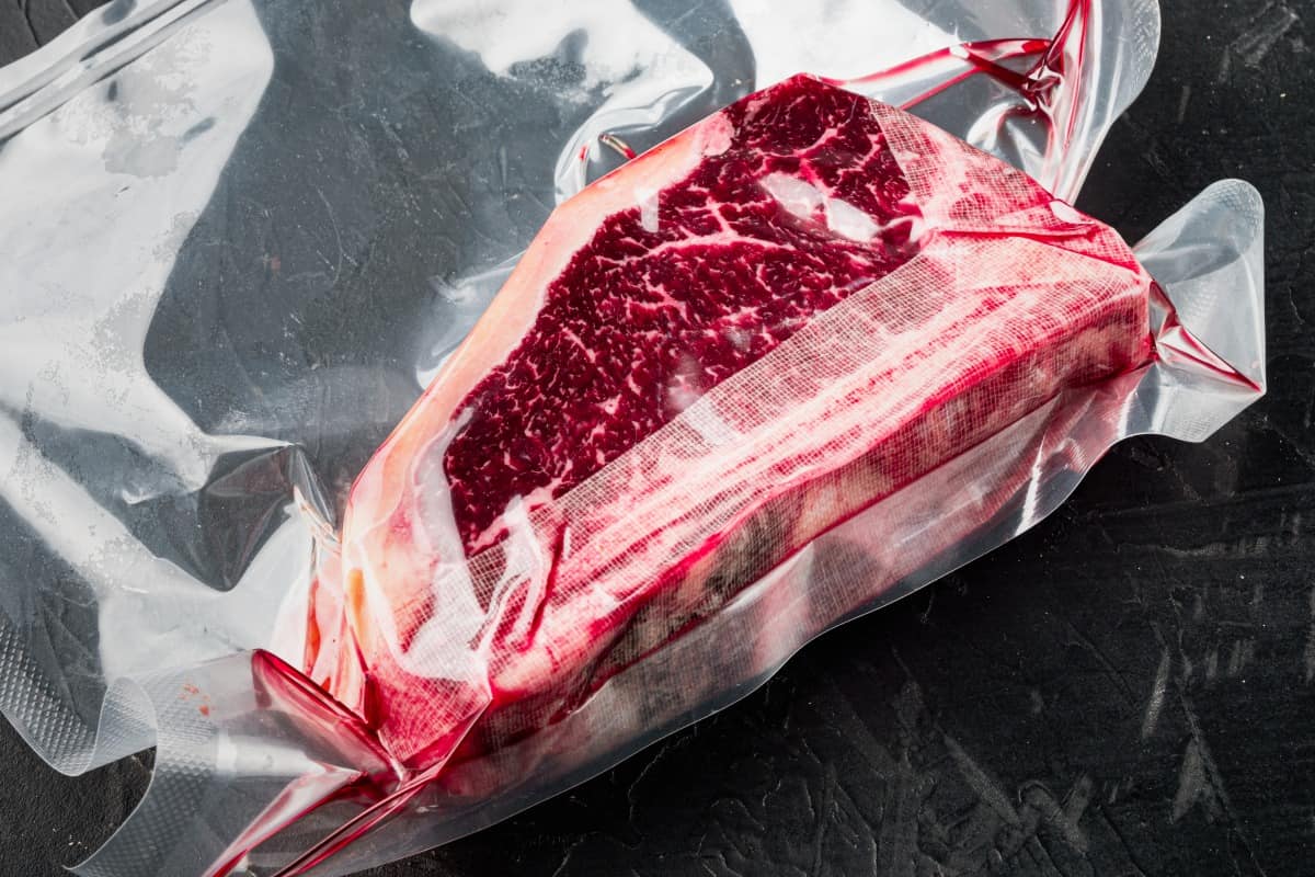 Large cut of beef in dry aging bag inside a refrigera.