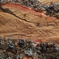 Close up of nice, moist beef ribs with a smoke ring and peppery rub crust.