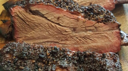 Close up of nice, moist beef ribs with a smoke ring and peppery rub crust.