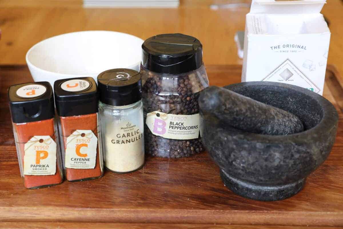 A pestle and mortar, and dry rub ingredients including pepper, salt, paprika, and a couple others
