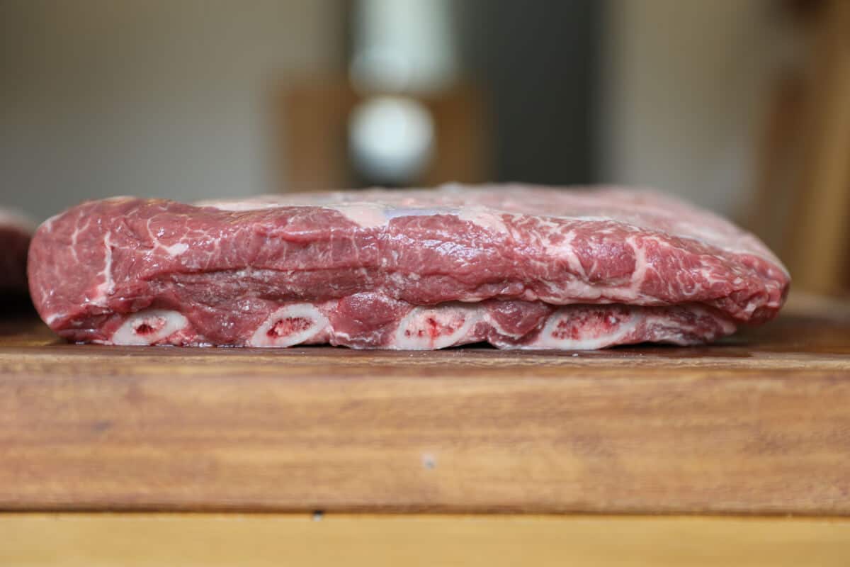 side view of a rack of beef short ribs showing the marbl.